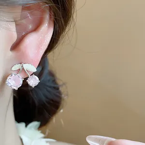 Exquisite close-up of pink cubic zirconia cherry stud earrings worn on female ear