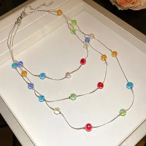 Detailed view of a three-layer necklace with vibrant faceted glass beads on silver chains.