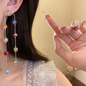 Detailed close-up view of elegant colorful glass bead tassel earrings worn by a model