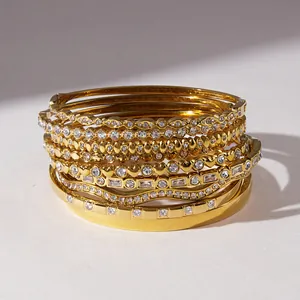 Detailed macro shot of luxury stackable gold stainless steel bangles with rhinestones.