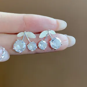 Detailed close-up of delicate cherry stud earrings with sparkling round-cut zircons