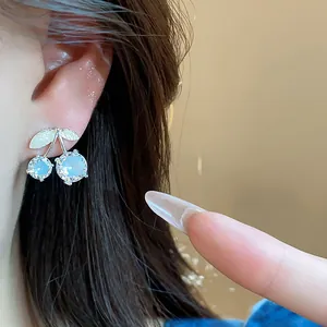 Close-up detail of exquisite zirconia cherry stud earrings worn on ear