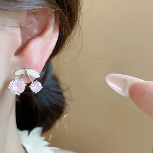Close-up of elegant cherry stud earrings with pink zircon and silver finish