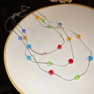 Detailed view of faceted multi-color glass beads on a three-layer silver chain
