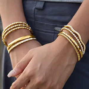 Elegant gold-plated titanium steel bangles with sparkling rhinestones on model's wrist.