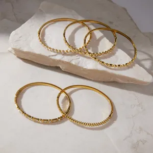 Macro view of gold-plated stainless steel bangles with sparkling rhinestone details