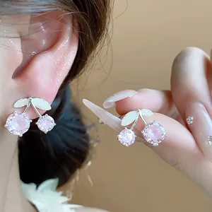 Detailed view of pink zircon cherry stud earrings with silver leaves and dainty design
