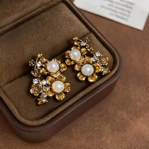 Primo piano di orecchini a fiore vintage con eleganti perle bianche e cristalli