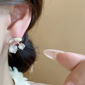 Close-up of elegant zircon cherry stud earrings with silver needles for women's accessory