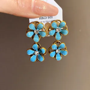 Vintage style light blue drip oil flower dangle earrings with a sparkling rhinestone center