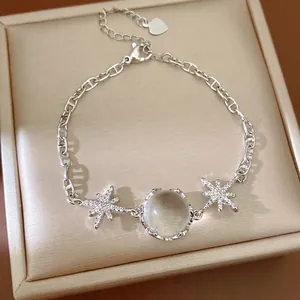 Silver starburst charm bracelet with a central round glass stone and sparkling zircons