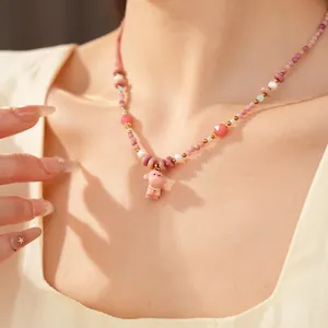 Macro view of pink ceramic beaded necklace featuring a cute puppy pendant and elegant pearls