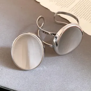 Vue détaillée de l'ensemble bague et bracelet ouverts avec incrustation ovale argentée.