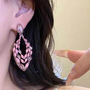Close-up of pink waterdrop earrings with hollowed-out rhinestone and enamel details