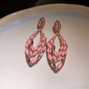 Detailed close-up of Bohemian pink water drop hollow earrings with silver needles
