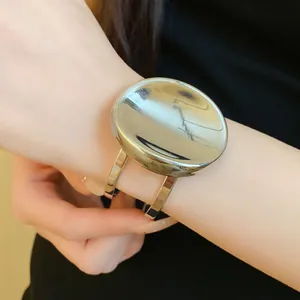 Vue détaillée d'un bracelet manchette moderne en métal argenté de forme ovale sur un poignet