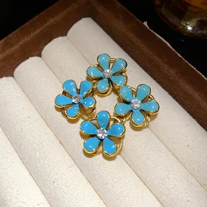 Close-up of light blue enamel flower earrings with central rhinestone in jewelry box