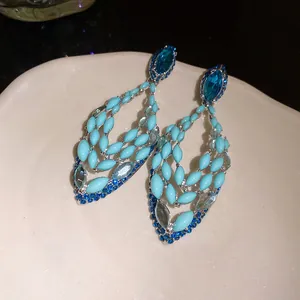 Detailed close-up of blue Bohemian hollow teardrop earrings with sparkling crystals
