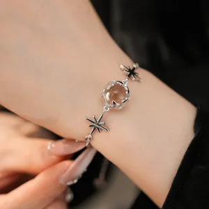 Detailed macro shot showing the star and glass ball motifs of a silver zircon bracelet