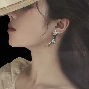 Detailed view of sparkling zircon star tassel stud earrings on an elegant model