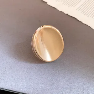 Vue détaillée d'une bague ovale dorée minimaliste avec une texture brossée chic