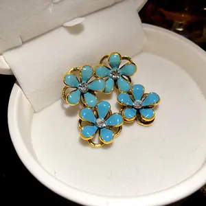 Close-up detail of vintage style blue enamel flower earrings with crystal center