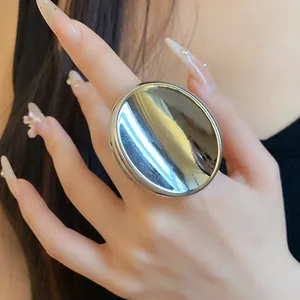 Vue détaillée d'une grande bague ovale ouverte en métal argenté minimaliste sur main