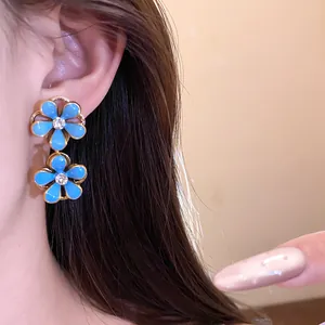 Close-up detail of vintage style blue enamel flower drop earrings with rhinestones