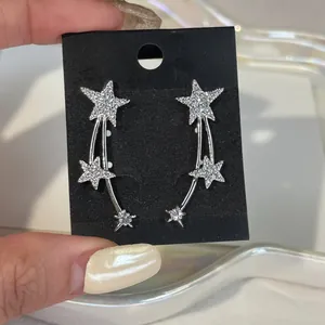 Detailed view of silver shooting star earrings featuring sparkling pavé set zircon stones