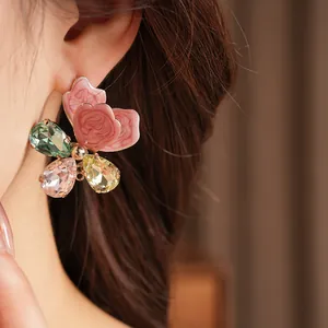 Macro view of a luxury floral earring featuring pink petals and vibrant crystal gems