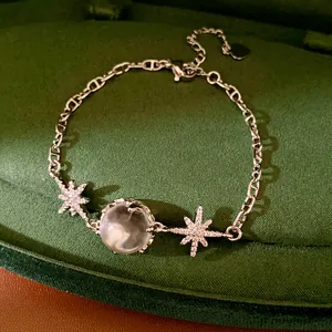 Close-up of elegant silver star bracelet with zircon and clear glass bead charm
