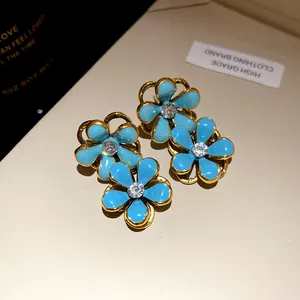 Elegant blue enamel flower earrings with sparkling rhinestone centers in vintage style.