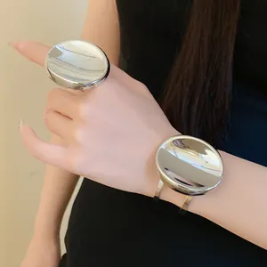 Gros plan sur une bague ovale en argent et un bracelet ouvert assorti sur un modèle.