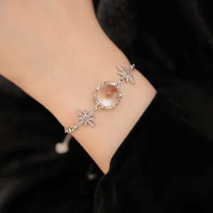 Elegant close-up of a silver zircon starburst bracelet featuring a clear round bead on a wrist.