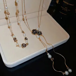 Vintage gold-tone necklace featuring black rose motifs and elegant white pearls