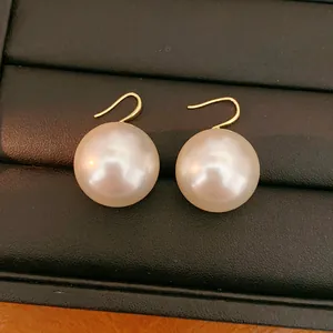 Elegant 18k gold-plated earrings with large lustrous white pearls shown on jewelry tray