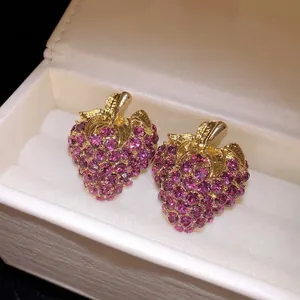 Boucles d'oreilles fraises en strass violets brillants avec finition dorée et aiguilles