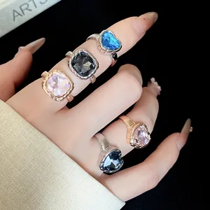 Detailed close-up showing colorful heart and square crystal open rings on a hand