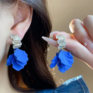 Eleganti orecchini a petalo blu Klein con zirconi mostrati in primo piano per donna.
