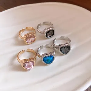 Detail of five faceted gemstone heart and square open rings in gold and silver tones.