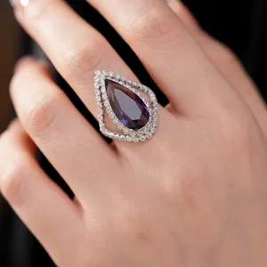 Luxurious palace style open ring with a large purple pear-cut zircon and pavé stones.