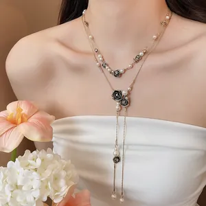Close-up detail of a vintage rose pearl tassel layered necklace worn by a fashion model