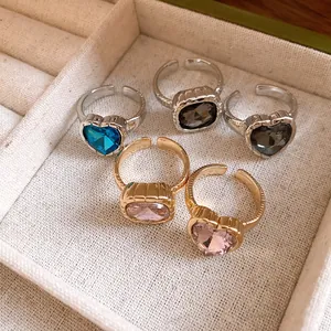 Detailed view of colorful heart and square crystal open-ended adjustable rings in display.