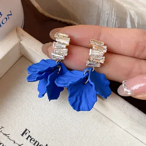 Dettaglio ravvicinato di orecchini a petalo blu Klein con eleganti perni in zircone.