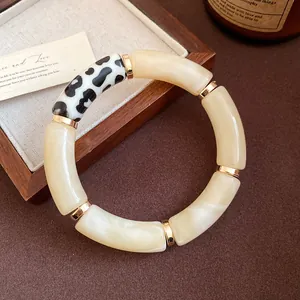 Close-up detail of a bohemian acrylic bangle with elegant marble and cow spot patterns