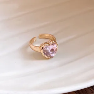 Close-up of exquisite heart-shaped pink gemstone on a textured gold-toned open ring for women