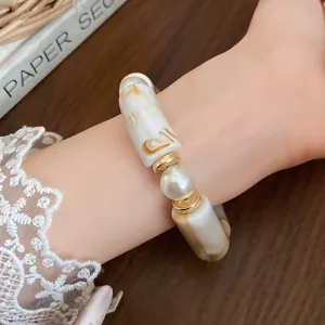 Close-up of bohemian marble-textured acrylic and faux pearl bracelet for women's jewelry