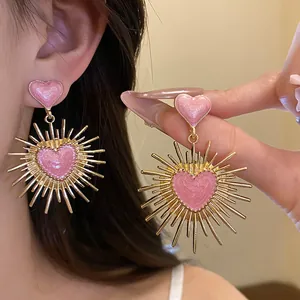 Gros plan détaillé de boucles d'oreilles vintage dorées avec cœurs roses scintillants