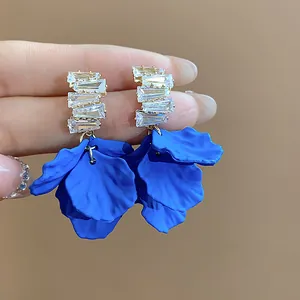 Macro dei dettagli degli orecchini a petalo in acrilico blu Klein con zirconi.
