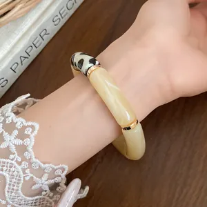 Detailed macro view of bohemian acrylic bracelet with cream segments and polka dot pattern
